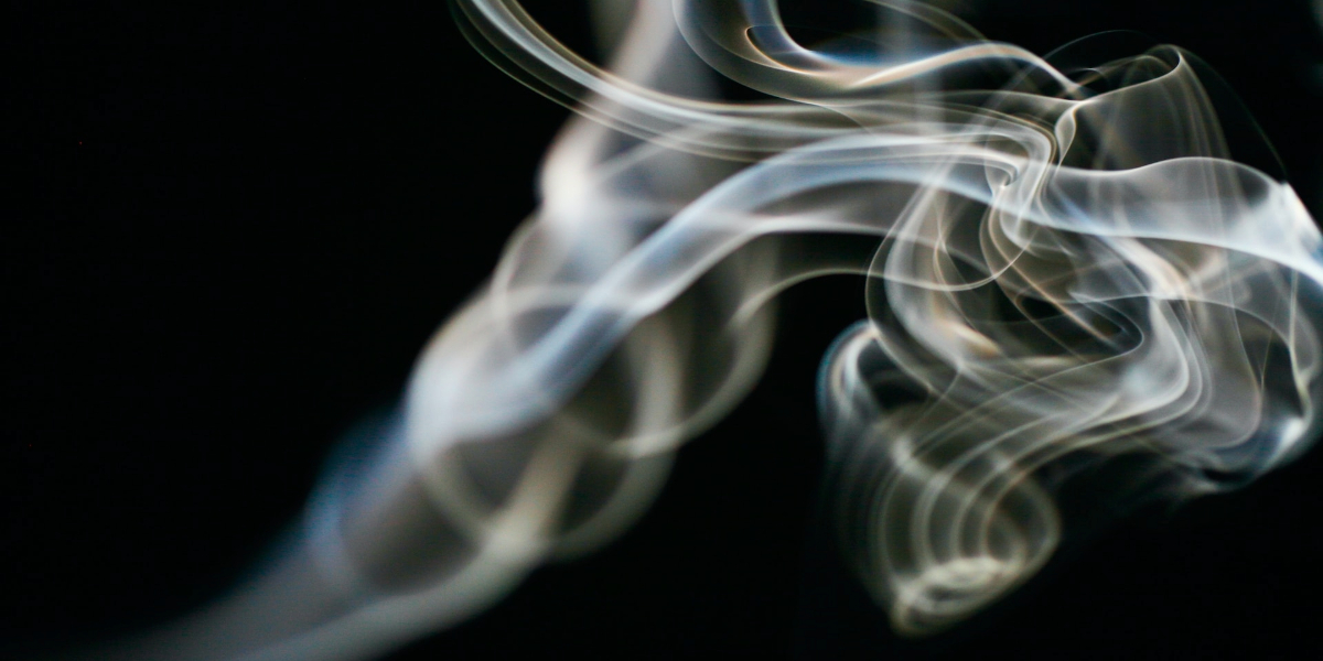 An image of white smoke swirling against a dark background